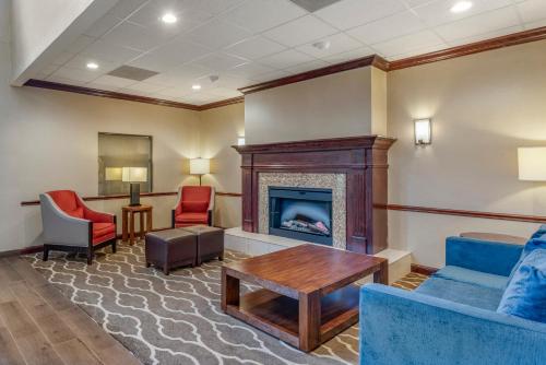 a waiting room with a fireplace and chairs at Comfort Inn & Suites St Louis-O'Fallon in O'Fallon