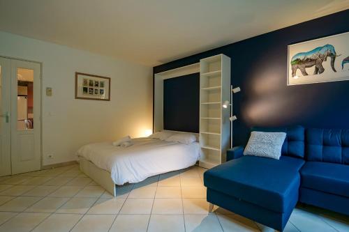 une chambre avec un lit et un canapé bleu dans l'établissement Le Bleu du Lac - 150m from the lake - terrace & parking in Sevrier, à Sévrier