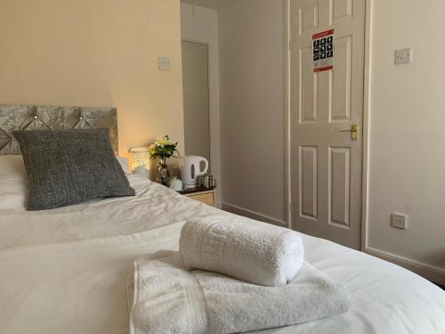 a bedroom with a white bed with towels on it at St Anne's Road Guest House in Exeter