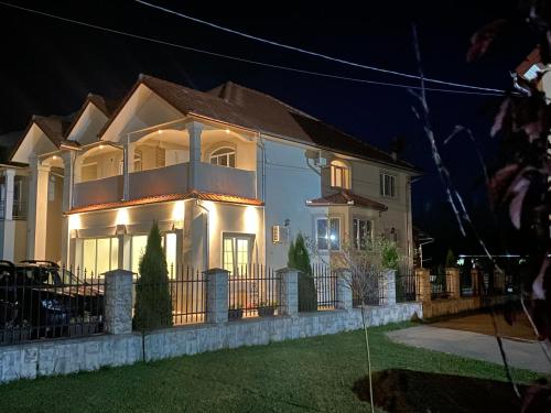 a large white house with a fence in front of it at Absolut Residence Hateg in Haţeg
