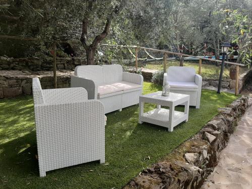 three white chairs and a table on the grass at Casa Vacanze Ada in Fiesole
