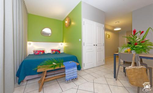 a bedroom with a bed and a table and a desk at Village Creole in Les Trois-Îlets