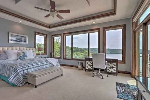 a bedroom with a bed with a ceiling fan and windows at Luxury Lake of the Ozarks Home with Boat Dock! in Kaiser