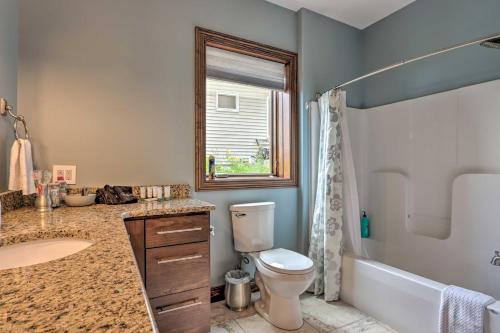 a bathroom with a toilet and a sink and a tub at Boat Dock and Kayaks Luxury Lake of the Ozarks Home in Kaiser