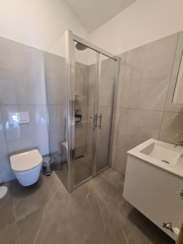 een badkamer met een douche, een toilet en een wastafel bij Villa Carpe Diem in Vantačići
