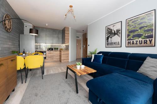 a living room with a blue couch and a table at City View Apartment in Iława
