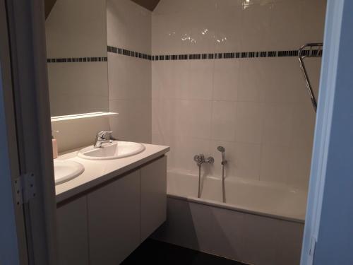 La salle de bains est pourvue d'un lavabo et d'une baignoire. dans l'établissement Duplex met zwembad Neoportus, à Nieuport