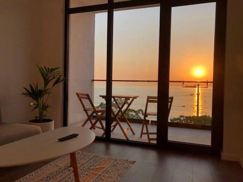 a living room with a table and a view of the ocean at Cabo Verde Boutique Hotel in Batumi