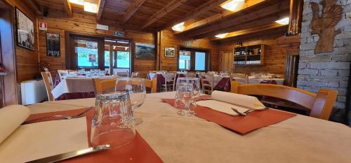 a dining room with tables and chairs with glasses and napkins at Camping Village Yolki Palki in Bognanco