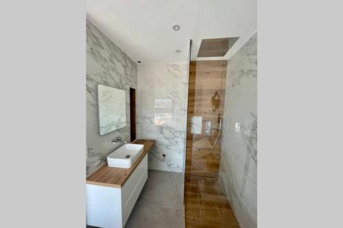 uma casa de banho com um lavatório e um espelho em Villa moderne avec Piscine - Porticcio em Grosseto-Prugna