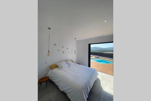 une chambre avec un lit et une vue sur une piscine dans l'établissement Villa moderne avec Piscine - Porticcio, à Grosseto-Prugna