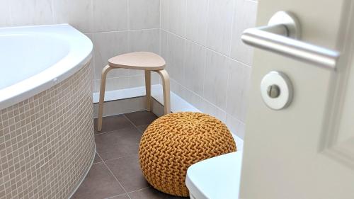 a stool in a bathroom with a toilet and a sink at Ferienwohnung "Birkenstrasse" in Bad Wiessee