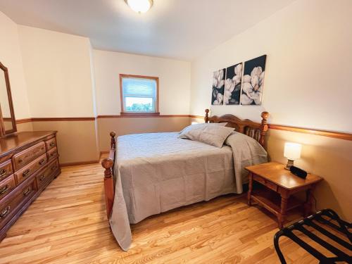 a bedroom with a bed and a wooden floor at 3 Bedroom home outside of Berlin, Patio with Hot Tub! in Millersburg