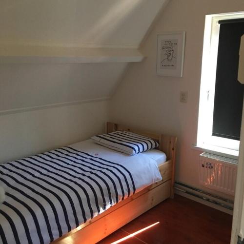 two beds in a room with a window at dreamingzeeland in Nieuwvliet