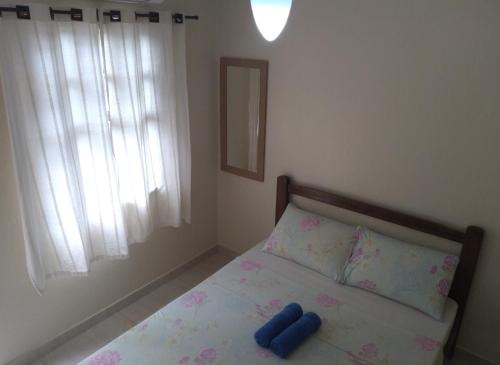 a bedroom with a bed with two blue objects on it at Pousada Marimbá in Trindade