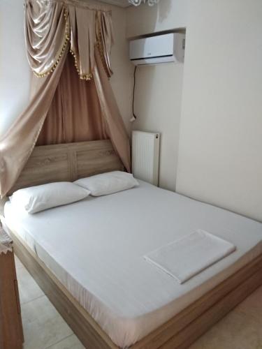 Penthouse Deluxe apartment at piraeus في بيرايوس: غرفة نوم بسرير أبيض مع مظلة
