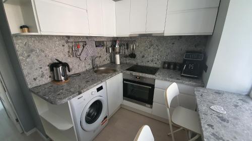 a kitchen with a washing machine and a sink at Anita's center apartment in Liepāja