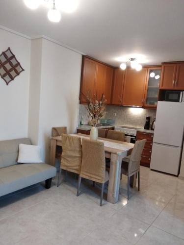 uma cozinha com uma mesa e cadeiras e um frigorífico em Penthouse Deluxe apartment at piraeus em Piraeus