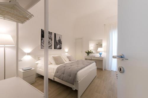 a white bedroom with a bed and a mirror at La Home42 Suite in Palermo