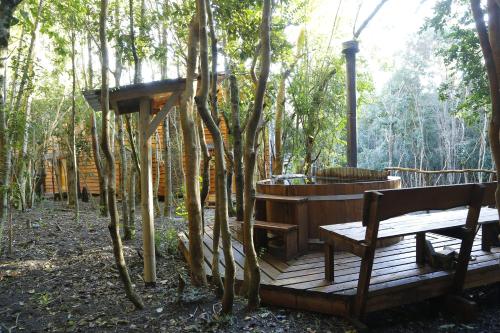 a wooden deck with a hot tub and a bench at Cabañas Ensenada Bosque Nativo in Ensenada