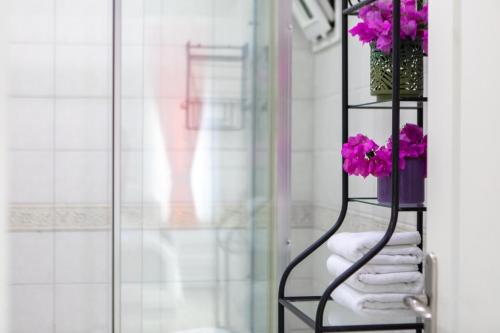 a towel rack with towels and flowers in a bathroom at Olya Boutique Hotel in Beldibi