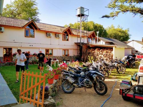 a group of motorcycles parked in front of a house at Hosteria y Cabañas Casa de Piedra in Trevelin