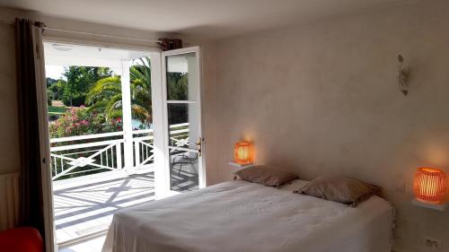 une chambre avec un lit et une porte coulissante en verre dans l'établissement Villa Piscine Golf Tennis Méditerranée, à Baillargues