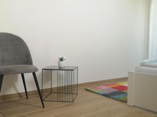 a chair and a side table with a plant on it at Forest House Balaton in Cserszegtomaj