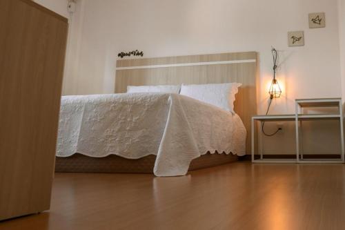 sypialnia z łóżkiem z białą kołdrą w obiekcie Belo Apartamento Central Master Collection w mieście Passo Fundo