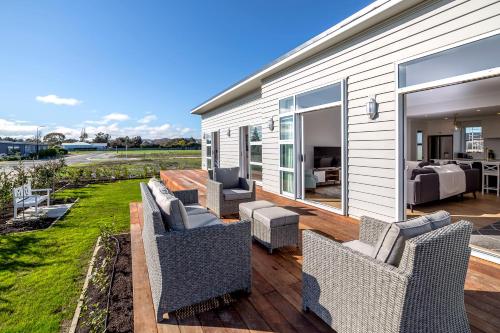 a deck with chairs and tables on a house at Three on Wilson in Martinborough 