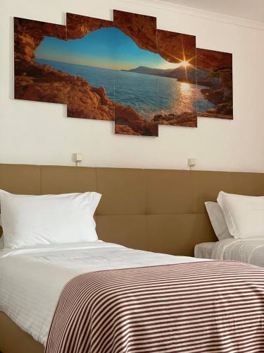 a bedroom with two beds and a painting on the wall at Hotel Rural A Coutada - Peniche in Atouguia da Baleia