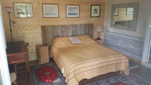 a bedroom with a bed in a wooden room at La petite Boulandre in Saint-Antoine-de-Breuilh