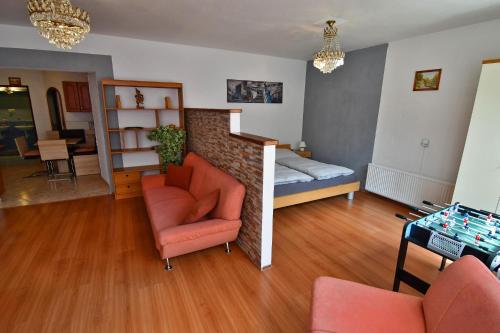 a living room with a bed and a couch and a chair at APARTMENTS V+K in Tatranska Strba