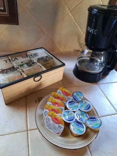 a tray of cupcakes on a plate next to a coffee maker at House de Fountas in Khandria