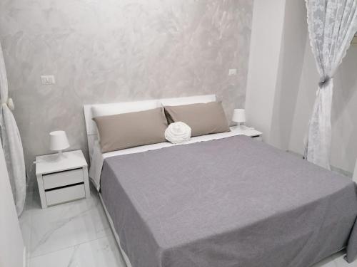 um quarto branco com uma cama e duas mesas de cabeceira em [Centro Storico] Casa Elegante per Famiglia em Nápoles