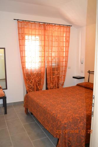a bedroom with a bed and orange curtains at Oasi Peppa in Ascea