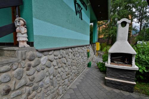 a stone wall with a fireplace next to a building at APARTMENTS V+K in Tatranska Strba