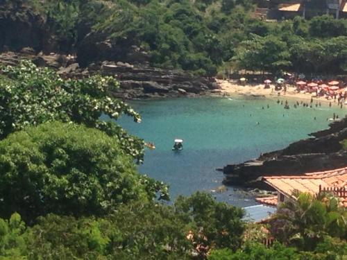 een strand met een stel mensen in het water bij Casa Praia dos Amores Ferradurinha e Geriba in Búzios