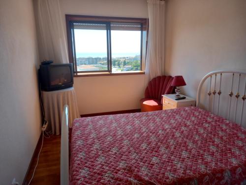 1 dormitorio con 1 cama, TV y ventana en Figueira House AL en Figueira da Foz