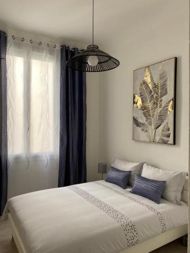 ein Schlafzimmer mit einem großen weißen Bett mit blauen Kissen in der Unterkunft Appartement Place des Promenades in Roanne