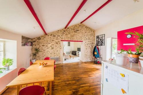 - un salon avec une table en bois dans l'établissement Appartement rouge avec jardin, à Eymoutiers