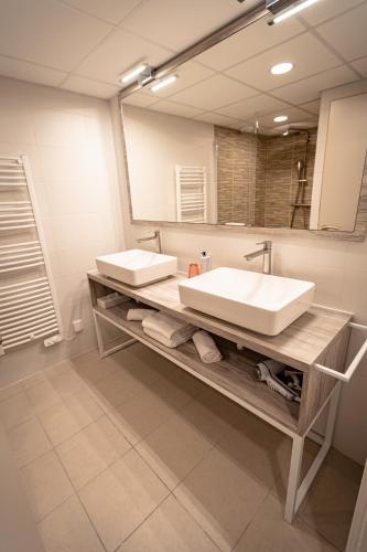 a bathroom with a sink and a mirror at Hotel Mercedes in Hossegor