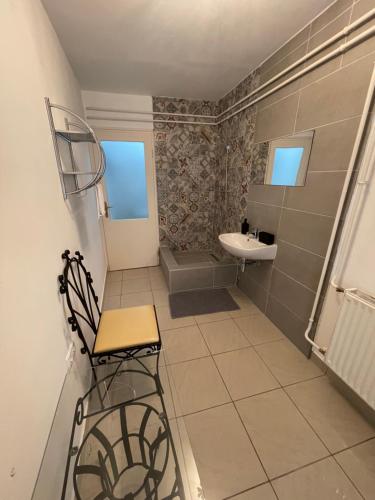 a bathroom with a sink and a chair in it at Lyrius Vendégház - Debrecen in Debrecen