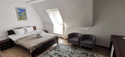 a bedroom with a bed and a chair and a window at Готель-ресторан "Олеся" in Berehove