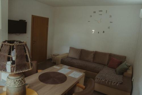 普盧日內的住宿－Apartment Silence，客厅配有沙发和墙上的时钟