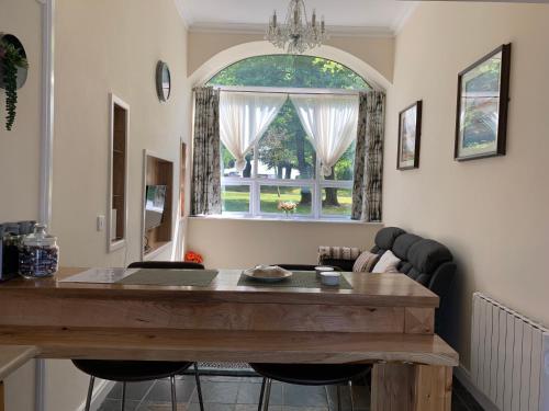 Cut Limestone Apartment Riverside Lodge في كارلو: غرفة معيشة مع طاولة ونافذة