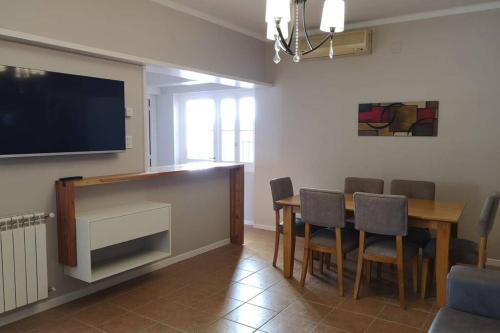 uma sala de jantar com uma mesa e uma televisão na parede em Precioso Departamento - Excelente ubicación em Mendoza