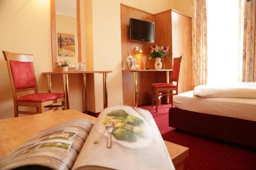 マルクヴァルトシュタインにあるガストホフ プリンツレゲント スペリアのベッドとテーブルが備わるホテルルームです。