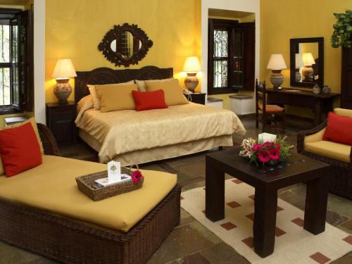 a bedroom with a bed and a couch and a table at Hotel Racquet Cuernavaca in Cuernavaca