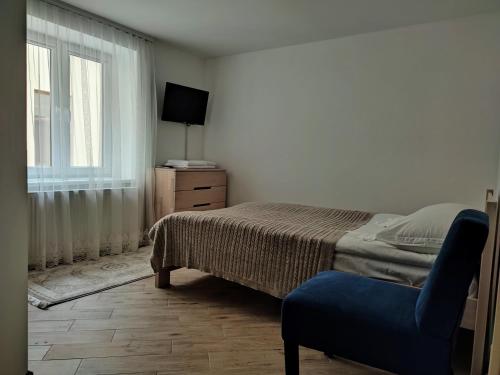 a bedroom with a bed and a chair and a window at Готель-ресторан "Олеся" in Berehove